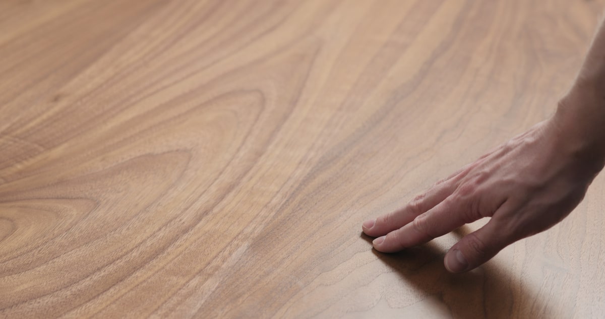 man hand touches black walnut dining table surface